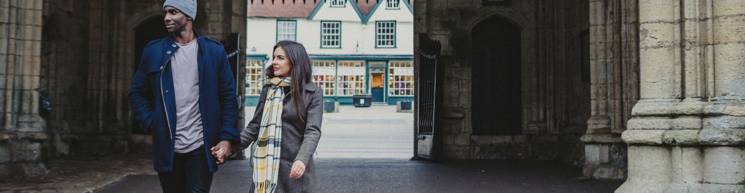 Couple walking through Abbey Gate 1500x390